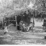 Image: Women and children resting by a temporary shelter