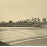 Image: Water cascades over a weir build across a wide river