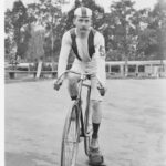 Image: cyclist wearing a cap and the number five on his forearm prepares for a race