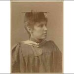 Image: A young woman poses for a photograph in university graduation cap and gown