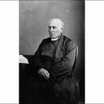 Image: Black and white photograph of seated elderly man wearing a clerical collar