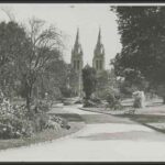 Image: Black and white photograph of a path winding through gardens towards a cathedral