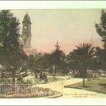 Image: Early coloured photograph of formal gardens with the Post Office tower visible in the background