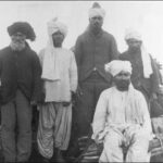 Image: Five Afghan men in traditional attire pose for a photograph