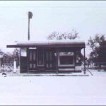 Image: A single-storey shop with two front doors, a front window, and corrugated metal awning