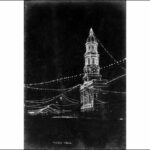 Image: A building with a tall tower and rotunda is illuminated by lights at night