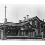 Image: A large house constructed of both stone and visible timber framing. Next to it is another large, two-storey stone house