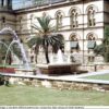 Image: stone fountain shaped like bathtub in front of stone buildings