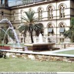 Image: stone fountain shaped like bathtub in front of stone buildings