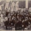 Image: A large group of people surround a foundation stone with plaque