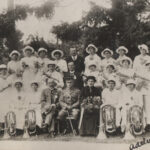 Band lined up in three tiers with their instruments and dignitaries