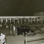 Image: parked cars and people milling around