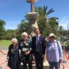 People standing in front of stone cross