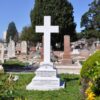 Image: large white cross surrounded by garden and other graves