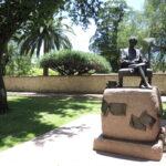 Image: bronze statue of seated woman with books