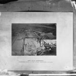 Image: Men working on structures over a flooding river