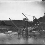 Image: Large wooden bridge structure over a running river