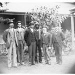 Image: Members of an exploring expedition pose for a photograph. An Afghan man with turban and western dress stands in the centre of the group