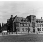 Image: A large, two-storey brick building with a central tower