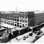 Image: a high angle photograph of a huge five storey building under construction. Scaffolding covers most of the building.