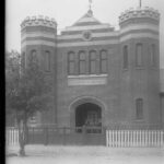 Image: A large, two-storey brick building built in mock-Tudor style, with two turrets flanking a large entrance door. A sign reading ‘Missions to Seamen’ is visible above the entrance door