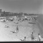 Image: People sunbathing and walking on a beach