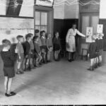 Image: woman showing children eye chart