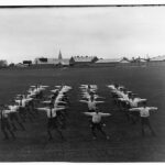 Image: boys in lines on oval with arms outstretched