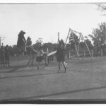 Image: A group of girls and boys play on playground equipment, including see-saws and swings