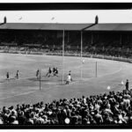 Image: A group of men play Australian Rules Football on an unidentified oval