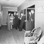 Image: people standing at reception desk