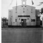 Image: street view of a white stone church flying Greek and Australian flags.