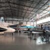 Image: group of planes in large hanger style building