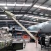 Image: group of planes in large hanger style building