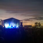 Image: crowd of people in front of stage and buildings