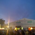 Image: crowd of people in front of stage and buildings