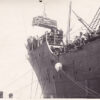 Image: casket being unloaded by crane from a ship