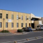 Image: Large brick building painted pale yellow