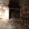 Image: interior of brick building, walls and cavity with large candle stand in foreground