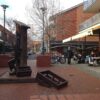 Image: bronze sculpture of column with apron in a brick courtyard of restaurants' patios