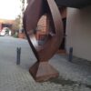 Image: steel quadrangle-shaped sculpture with rounded edges and a geometric hole in the middle