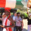 Image: man carrying drum on his head in front of crowd