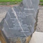 Image: A rough stone monument with text inscribed on a single polished flat face. The text is a poem entitled ‘Wirranendi’