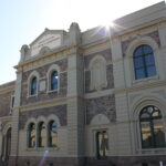 Image: A large, two-storey stone building with the words ‘Institute of Arts & Sciences’ painted on its front façade