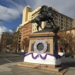 Image: large wreaths of woollen violets on statue of horse and rider