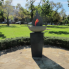 Image: memorial on a plinth designed as a red flame emerging from a circular bowl