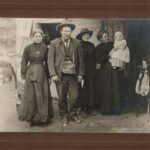 Image: group of people, old woman on right holding young baby in arms