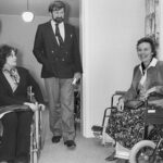 Black and white image of three people sitting in a room together