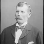 Image: Black and white photograph of a young August Wilhelm Pelzer with a moustache