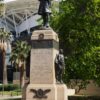 Image: Bronze statue of a man atop a granite pillar